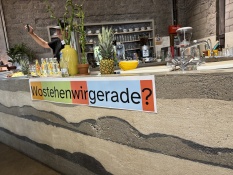 Methoden: Auf einer Theke stehen mehrere Getränke und eine Person steht dahinter. Unterhalb der Theke steht die Frage Wo stehen wir gerade?